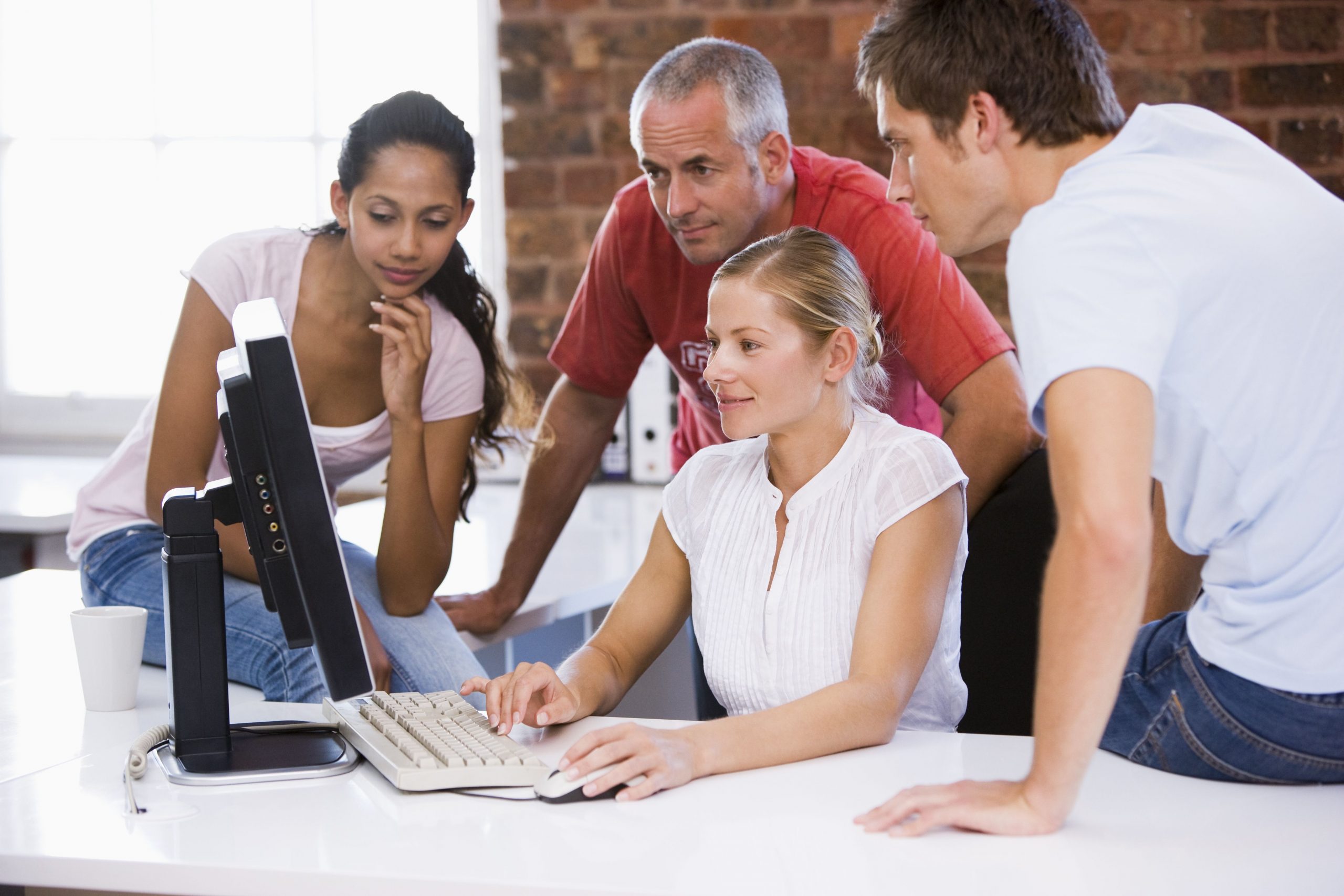 Group of employees looking at a computer